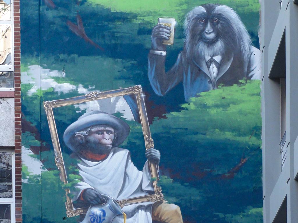 Unterschiedlich eingekleidete Affen gehen Tätigkeiten wie Filmen, Telefonieren und Trinken nach