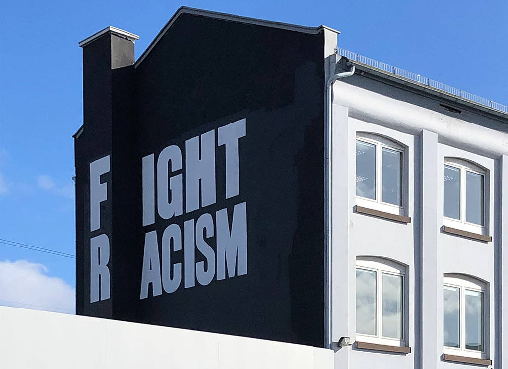 Fight Racism - Slogan mit weißer Schrift auf schwarzem Hintegrund
