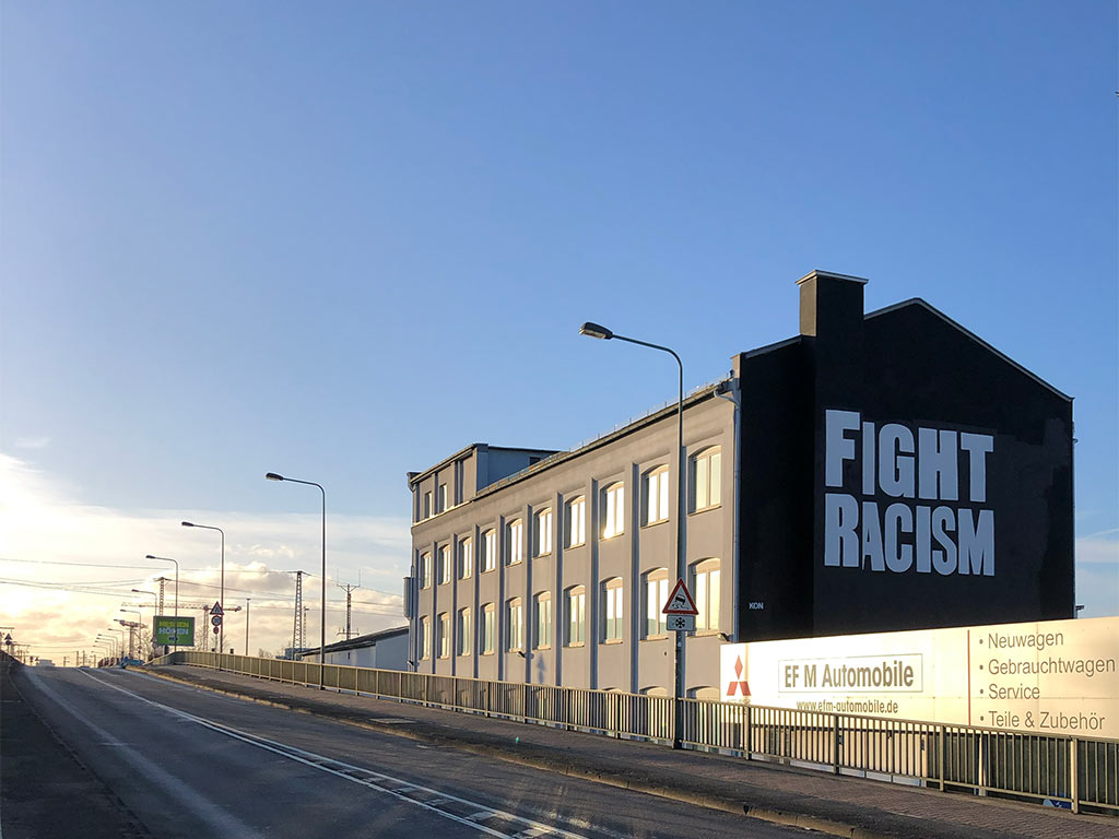 Fight Racism - Slogan mit weißer Schrift auf schwarzem Hintegrund