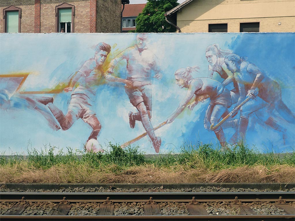 40 m breite Wand mit Sportmotiven zu Fußball, Hockey, Radfahren, Rudern, Schwimmen und Tennis