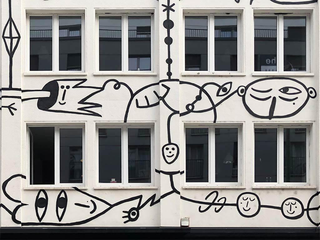 Schwarz-weiß-Illustration mit mehräugigen Gesichtern an Fassade im Bahnhofsviertel