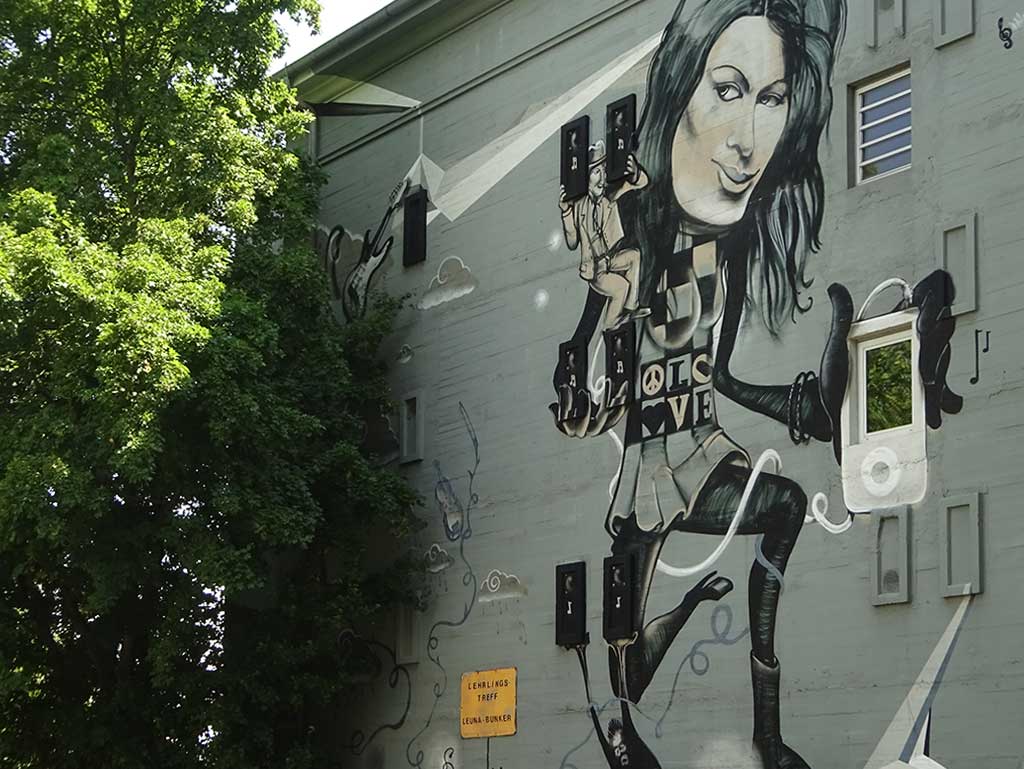 Künstlerich gestaltete Front des Leunabunkers in Frankfurt-Höchst zeigt junge Frau mit einem iPod
