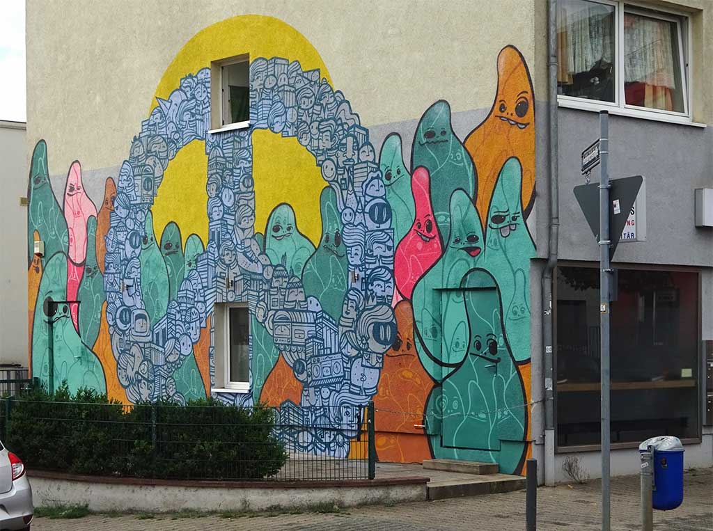 Cityghosts und die Figuren von PYC zu einem Peace-Symbol geformt an Hausfassade in Frankfurt-Sachsenhausen