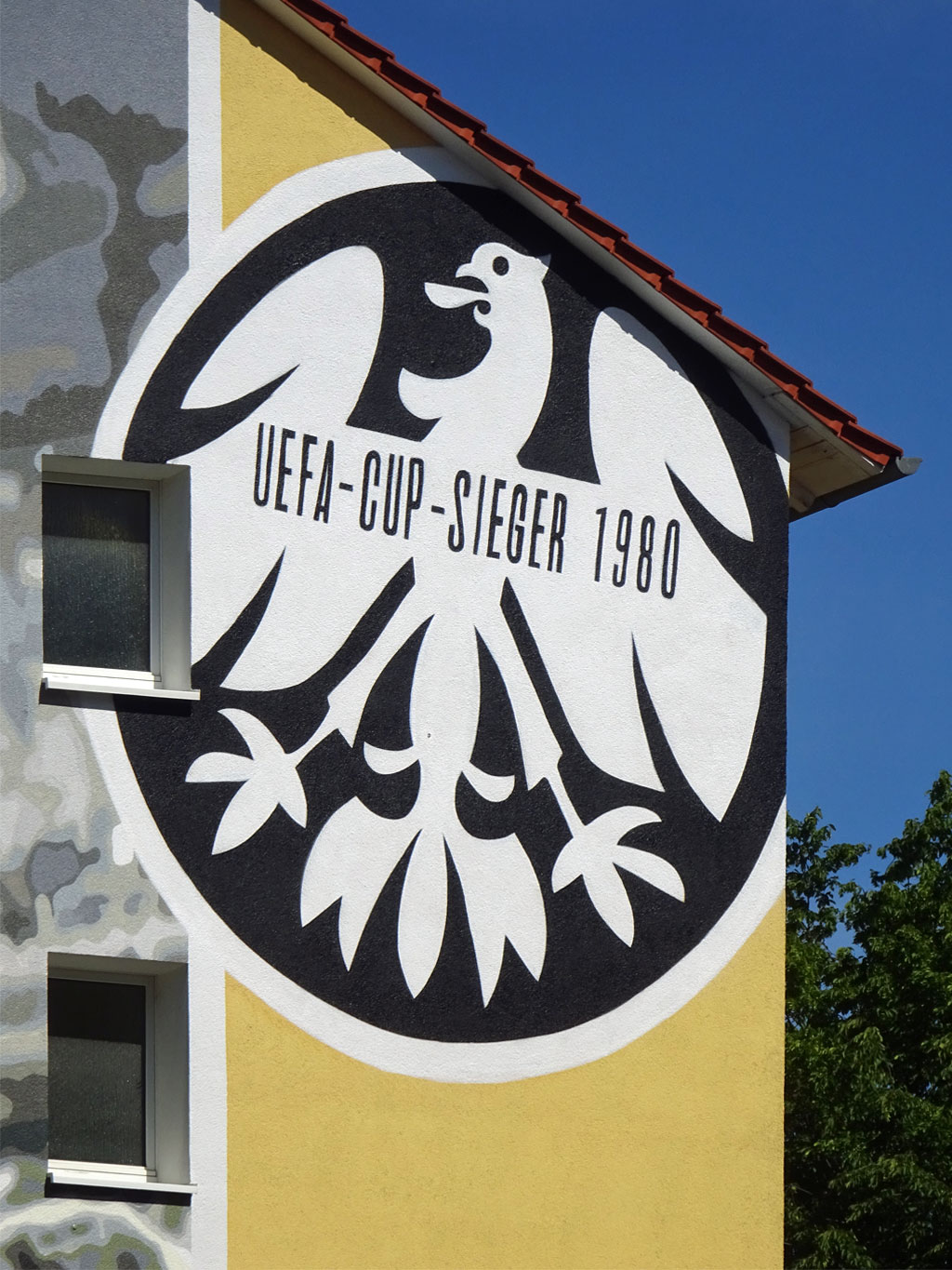 Mural mit großem Bild von Charly Körbel mit UEAFA-Cup in den Händen