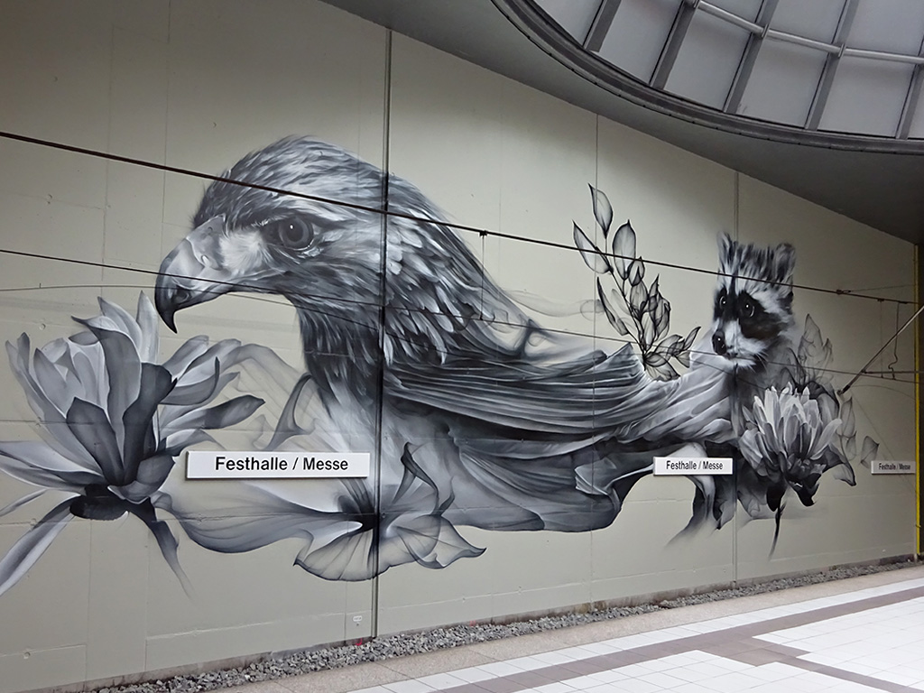 Großes Partnerstädte-Wandbild in U-Bahn-Station Festhalle/Messe in Frankfurt zeigt Adler (für Frankfurt) und Waschbär (für Toronto)